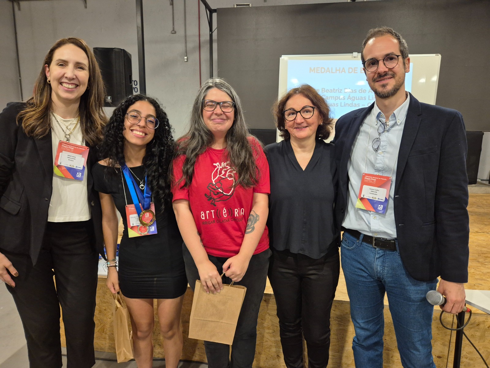 Anne recebendo a medalha de bronze da etapa final acompanhada da profa. Alice e com profa. Mitieli Seixas (UFSM) e Gustavo Coelho (CIB) - idealizadores e organizadores da I Onfiil - e com a profa. Solange Dejeanne (UFN), jurada na etapa nacional Anne recebendo a medalha de bronze da etapa final acompanhada da profa. Alice e com profa. Mitieli Seixas (UFSM) e Gustavo Coelho (CIB) - idealizadores e organizadores da I Onfiil - e com a profa. Solange Dejeanne (UFN), jurada na etapa nacional